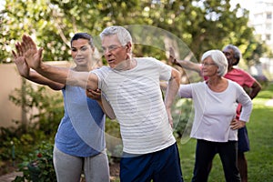 Trainer showing stretching exercise to senior people