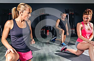 Trainer teaching stretch exercises to fitness class