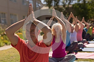 Trainer training senior people in performing yoga