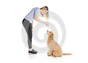 Trainer woman with his Golden Labradoodle dog isolated on white background