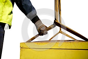 Trainesd rigger construction worker wearing heavy duty glove holding safety tag line on two tones yellow lifting sling