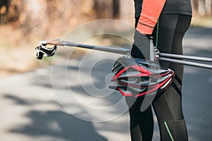 Training an athlete on the roller skaters. Biathlon ride on the roller skis with ski poles, in the helmet. Autumn photo