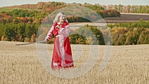 Training in the autumn field - a belligerent woman wields with a sword