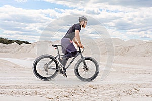 Training a bicyclist in a chalky quarry. A brutal man on a fat bike.