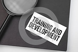 Training and Development word on paper and magnifying lens