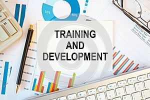 Training and Development is written in a document on the office desk, diagram and keyboard