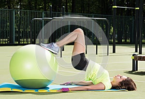 Training on the fit ball. Horizontal portrait. Young woman doing