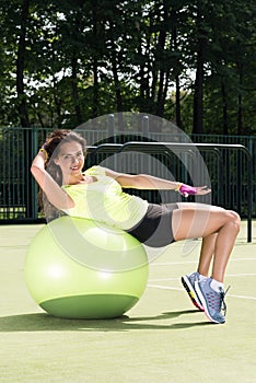 Training on the fit ball. Young woman doing sports exercises on the ball for training