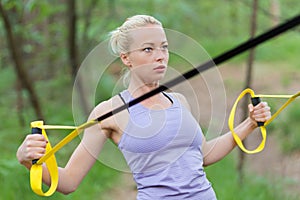 Training with fitness straps outdoors.