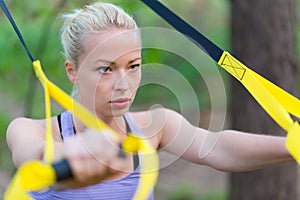 Training with fitness straps outdoors.