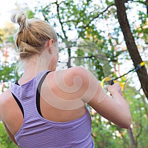 Training with fitness straps outdoors.