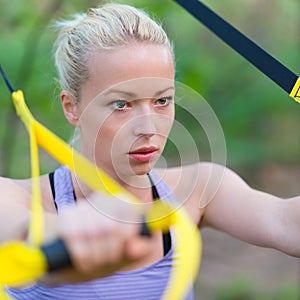 Training with fitness straps outdoors.