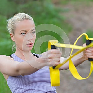 Training with fitness straps outdoors.