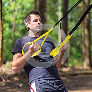 Training with fitness straps outdoors.