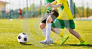 Training and football match between youth soccer teams. Young boys kicking soccer game