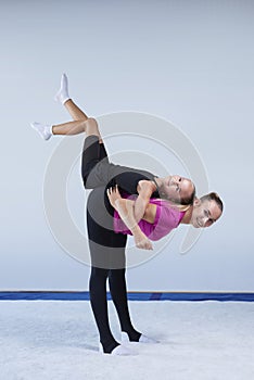 Training in the gym class. A little girl under the guidance of a trainer performs exercises. Gymnastics concept