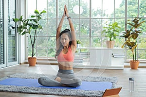 Training at home. Young asian woman doing yoga exercises with meditating, breathing and relaxing.