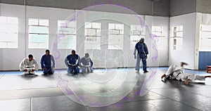 Training judo students in gis performing throws in bright dojo hall, with mats and windows