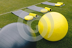 Training mats, foam rollers, cones, trampoline, gym balls and  balance cushions on training grass field. Equipment set for soccer