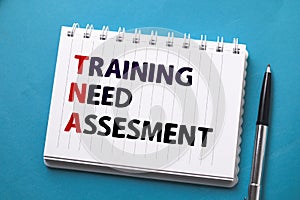 Training Need Assesment, text words typography written on paper against on blue background, life and business motivational