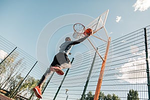 Nice strong young man playing basketball alone photo