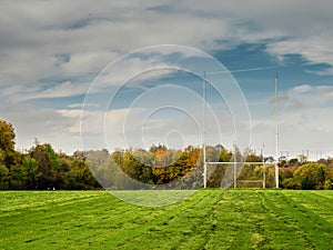 Training pitch for Irish National sport camogie, hurling, rugby and Gaelic football with tall goal posts and freshly cut grass.