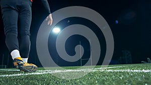 Training player kicks a ball, back view.