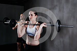 Training to become fighting fit. two people lifting barbells during a gym workout.