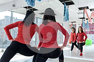 Training together. Portrait of two fit young women exercising on fitness in the bright gym