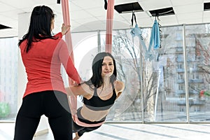 Training together. Portrait of two fit young women exercising on fitness in the bright gym