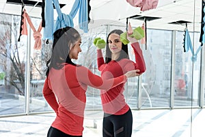 Training together. Portrait of two fit young women exercising on fitness in the bright gym