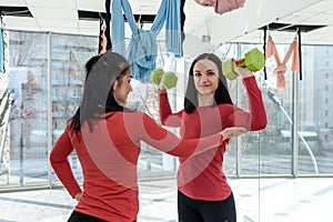 Training together. Portrait of two fit young women exercising on fitness in the bright gym