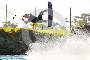 Training, wakeboard and extreme sports with man in lake for action, summer break and travel vacation. Wave, adrenaline