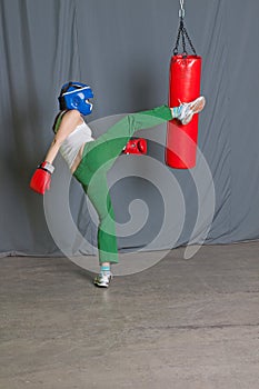 Training woman kicks punching bag