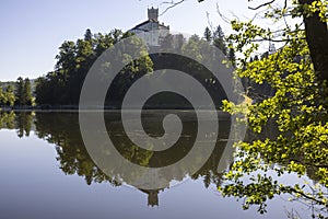 Trakoscan castle surrounded by the lake and forested hills