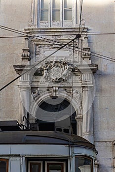 Tram in front of the Catholic Church in Lisbon with stucco and bas-reliefs with angels on the facade