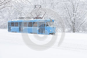 Tram goes along the street during snowstorm in Moscow
