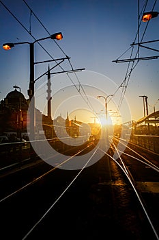 Tram railways in city during sunset.