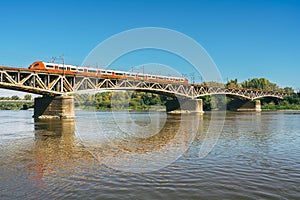 Tram running across Swietokrzyski bridge over the Vistula river in Warsaw, Poland in a bright sunny day