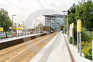 Tram stop with atforms, ed and blank billboards in a business district