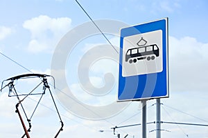 Tram stop sign against blue sky. Space for text