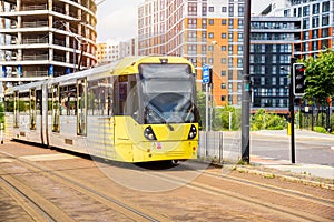 Tram on a traway running along a street in a suburban district