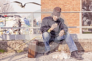 Tramp eating bread sitting in landfills