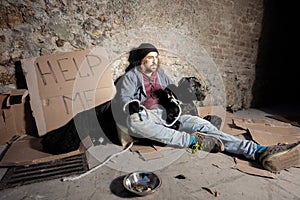 Tramp hugging his dog sitting on the city sidewalk