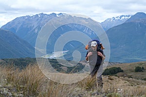 Tramper walks uphill in the mountains photo