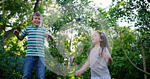 Trampoline, happy or kids jump in backyard for fun games on holiday vacation to relax together. Wellness, bounce or