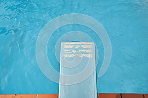 Trampoline infront of blue water of the pool