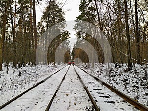 Trams going on rails in snowy winter forest