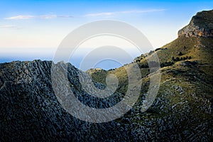 Tramuntana near Sa Calobra, lone house in the mountains at sunset, rocks, green pastures, mediterranean sea, blue sky, Mallorca,