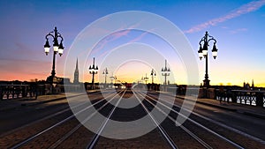 Tramway rails tracks in sunset light at Pont de pierre crossing Garonne river, Bordeaux,France